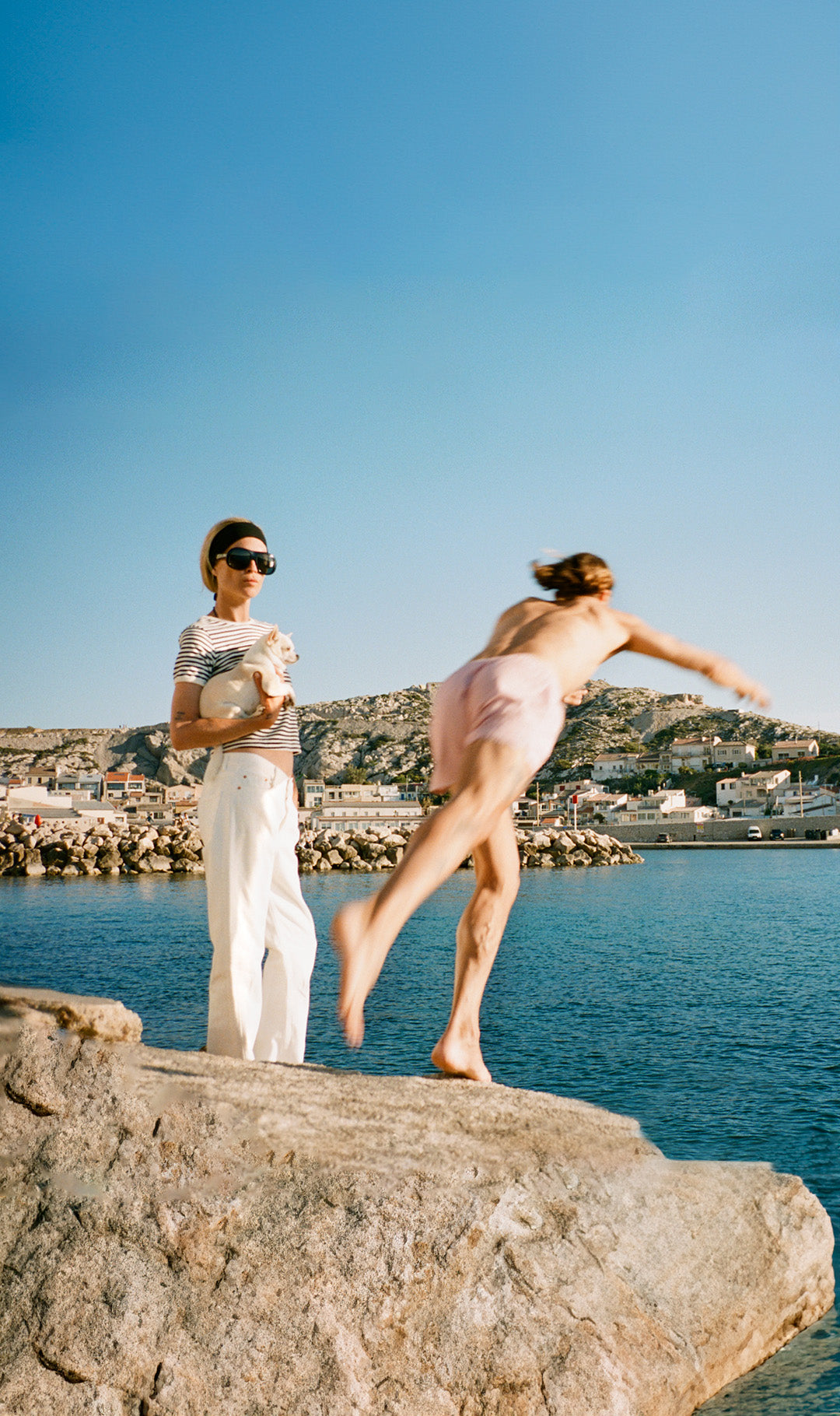 Erin Wasson standing on the rocks in Marseille wearing the Frankie Shop.