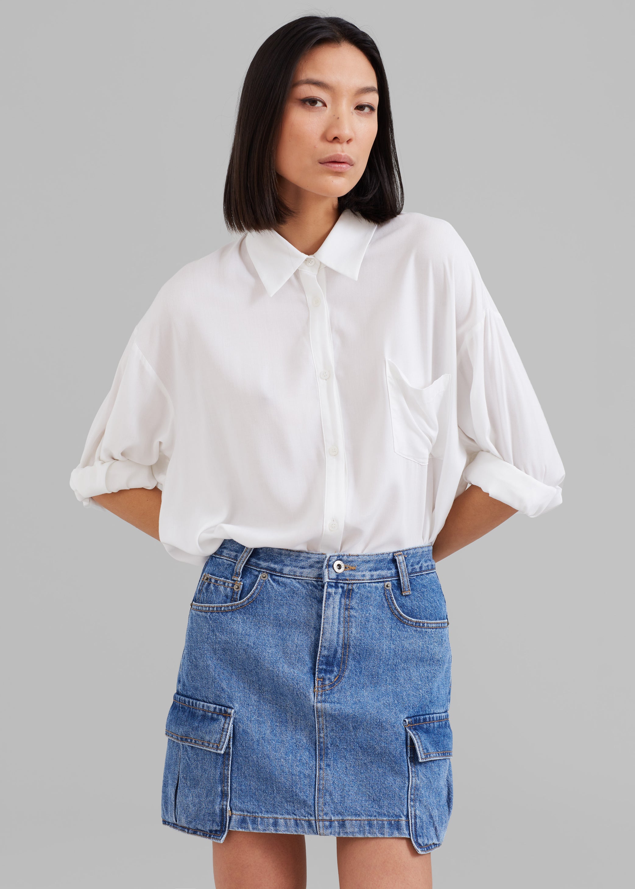 Frankie model wearing the Hanna silky oversized shirt paired with the Taylor denim cargo skirt.