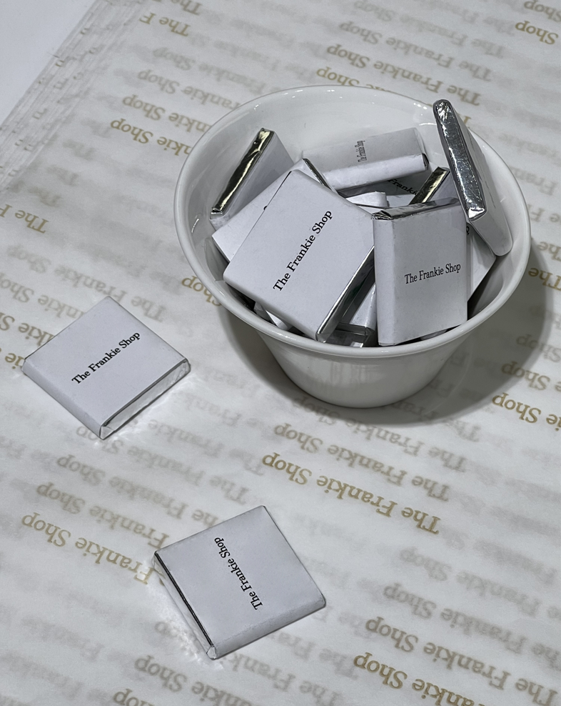 A close up of The Frankie Shop chocolates placed on The Frankie Shop wrapping paper.  