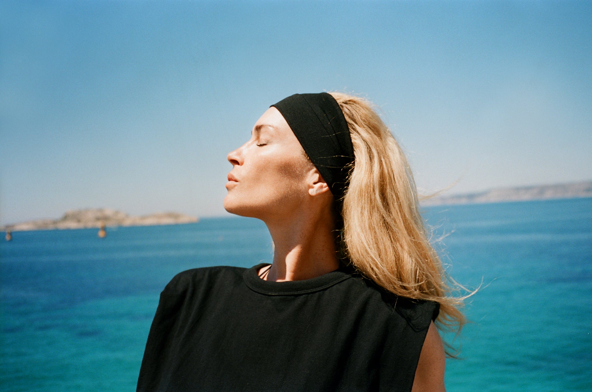 Close up of Erin Wasson against the beach wearing The Frankie Shop Eva padded shoulder tee. 